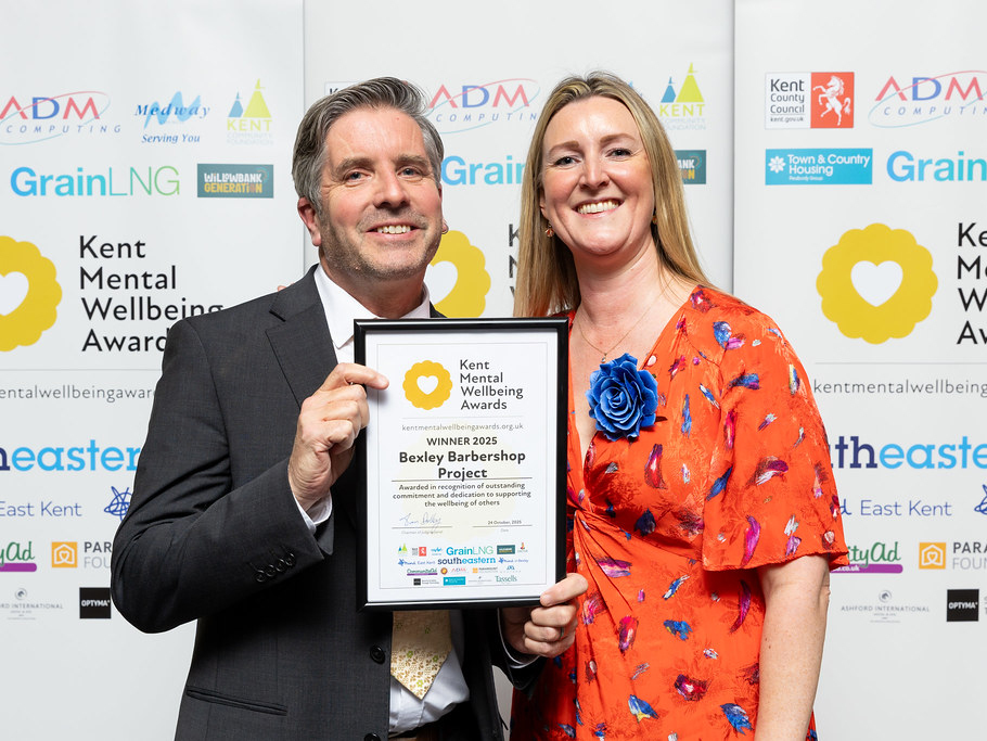 Dr David Palmer being presented with the award certificate for our Bexley Barbershop Project