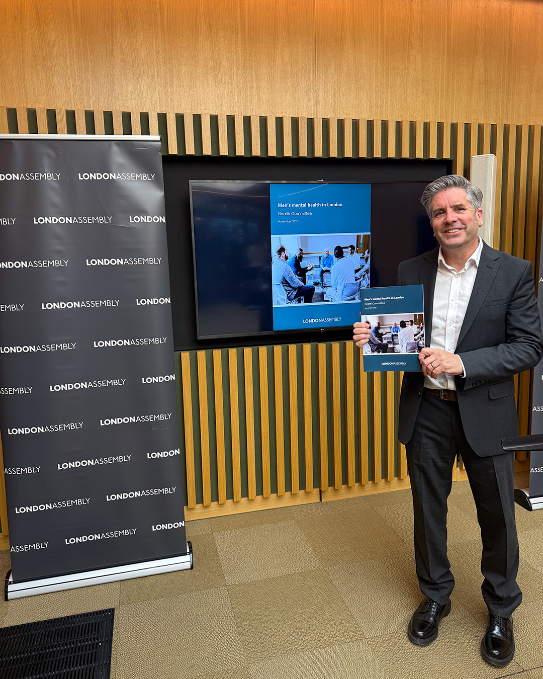 Dr David Palmer stood holding the Men