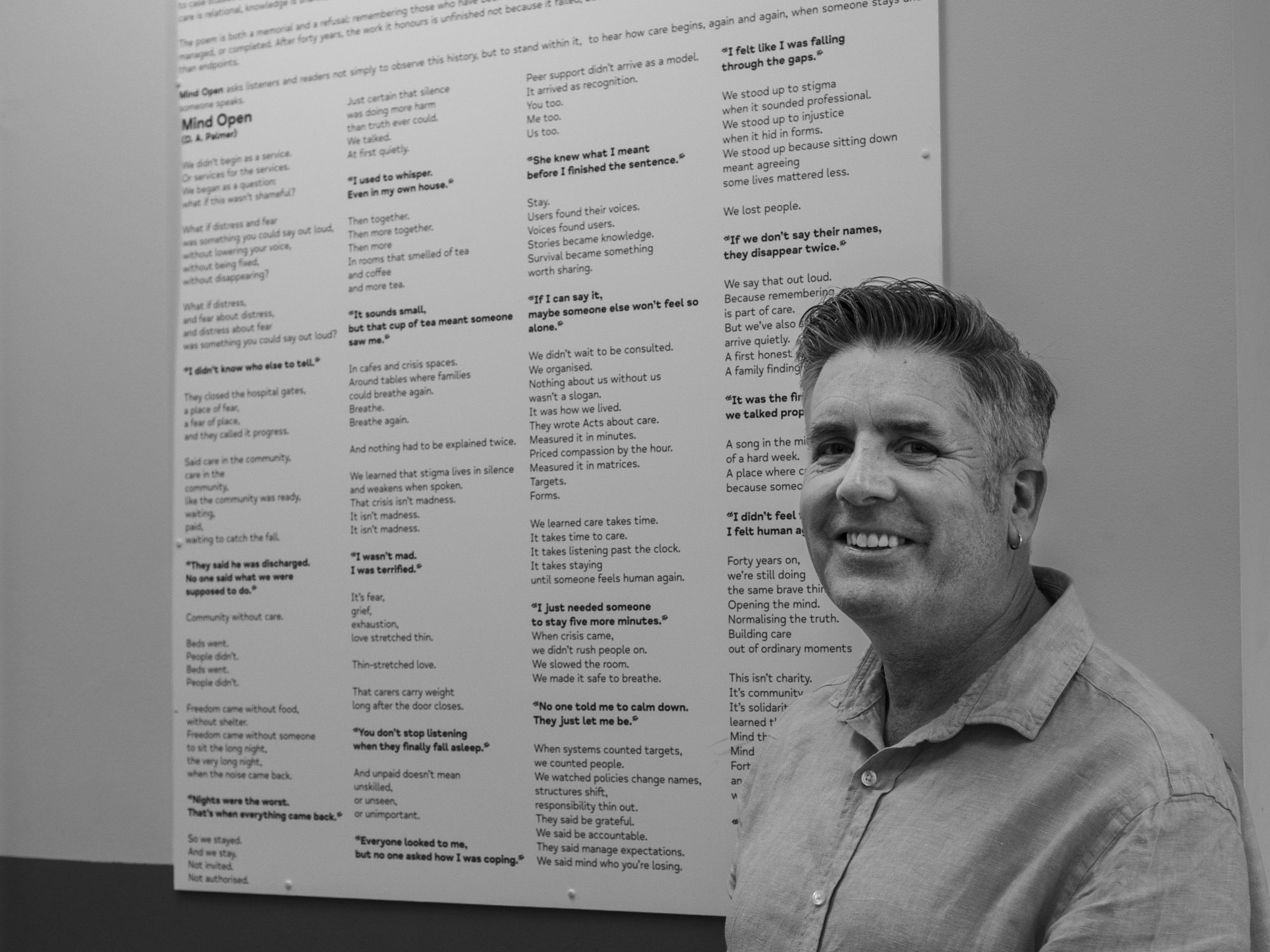 Dr David Palmer, CEO of Mind in Bexley and newly elected Chair of Mind in London is photographed in front of an information board celebrating the 40th anniversary of Mind in Bexley